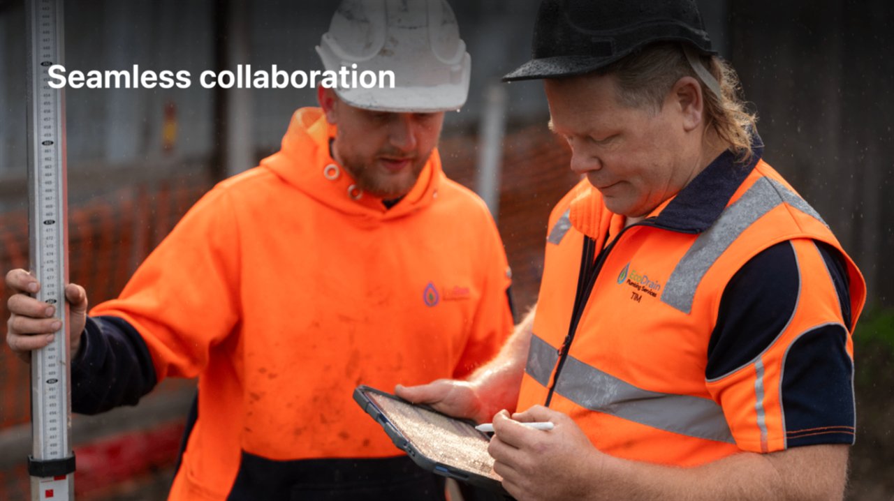 EcoDrain crew reviewing live job data on a tablet